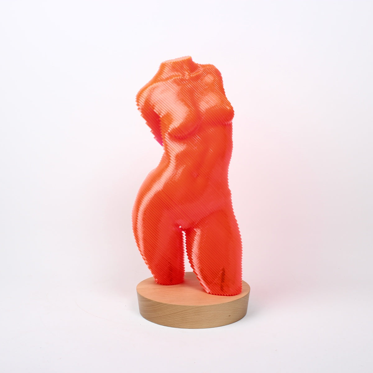 A sculpture of a female torso made from bright orange acrylic lamination