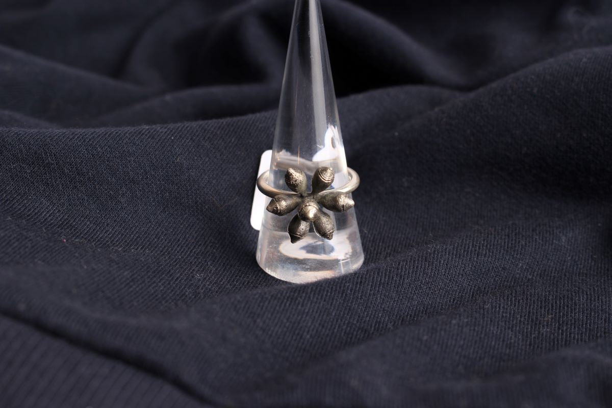 A sterling silver gum ring on a black fabric backdrop