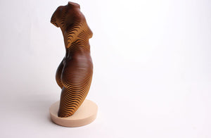 A sculpture of a female torso made from laminations of timber