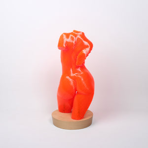 A sculpture of a female torso made from bright orange acrylic lamination