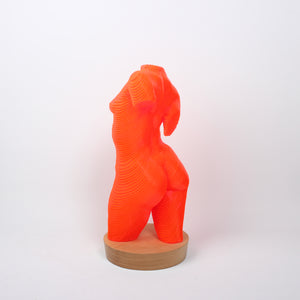 A sculpture of a female torso made from bright orange acrylic lamination