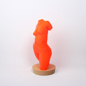 A sculpture of a female torso made from bright orange acrylic lamination