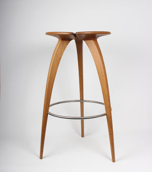A three legged oak bar stool